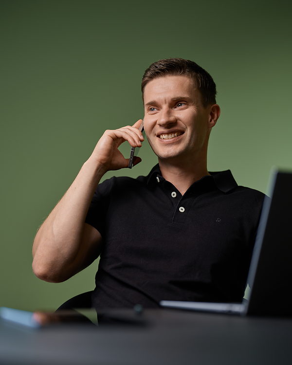 Wolfgang Duttlinger am Schreibtisch im Telefonat, neben ihm ein aufgeklappter Laptop